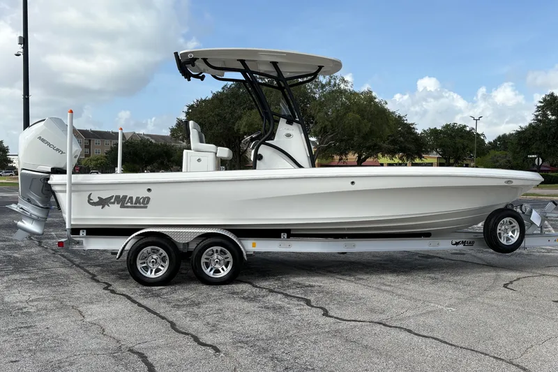 Slide: The Image of 2026 Mako 24 APEX boat on trailer, parked outdoors under a cloudy sky. - 5