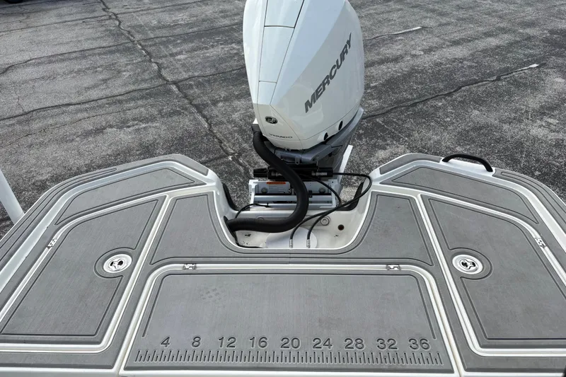 Slide: The Image of 2026 Mako 24 APEX boat with Mercury engine on textured deck. - 13