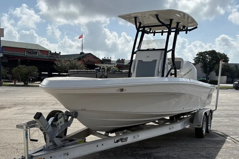Slide: The Image of 2026 Mako 24 APEX boat on trailer in parking lot under cloudy sky. - 0