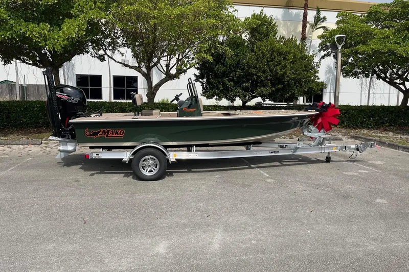 Slide: The Image of 2026 Mako 18 Pro Skiff Backwater Edition on trailer, parked outdoors with trees in background. - 1
