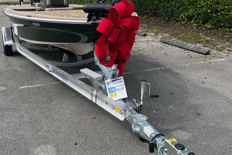 Slide: The Image of 2026 Mako 18 Pro Skiff Backwater Edition on trailer with red bow, parked outdoors. - 15