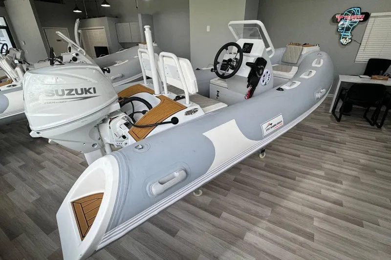 The Image of 2026 East Marine 360 inflatable boat with Suzuki outboard motor in showroom. - 0