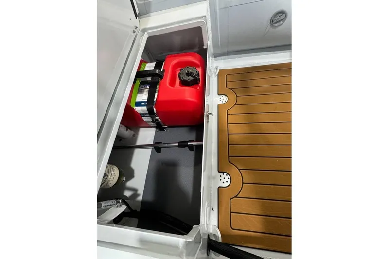 Slide: The Image of Open storage compartment in East Marine 360 boat, featuring a red fuel tank, 2026 model. - 12