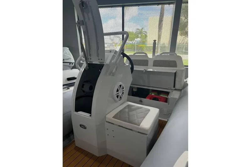 Slide: The Image of 2026 East Marine 360 boat interior with steering console and cushioned seating. - 19