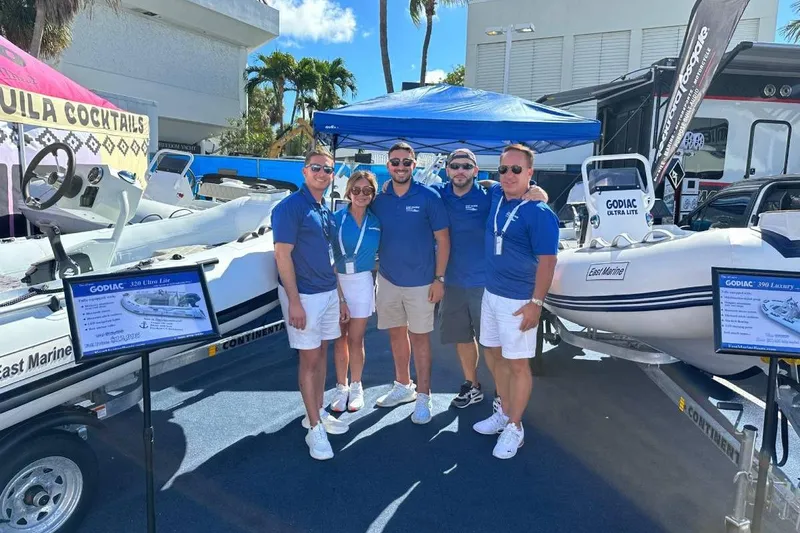 Slide: The Image of Group posing with East Marine 360 boat at outdoor event, 2026 model. - 22