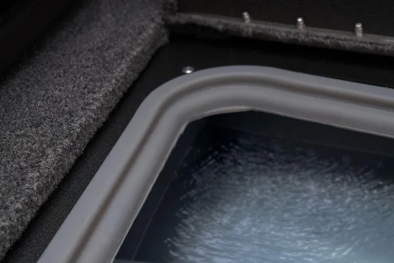 Slide: The Image of Open storage compartment in 2026 Tracker Targa V-18 WT boat, featuring gray interior and black straps. - 21