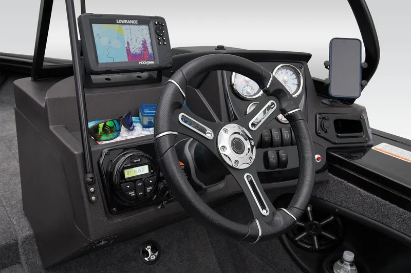 Slide: The Image of 2026 Tracker Targa V-18 WT interior with cup holders and carpeted flooring. - 23