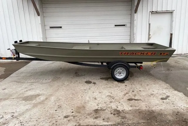 The Image of 2026 Tracker Grizzly 15 Jon boat on trailer, parked outside a garage. - 0