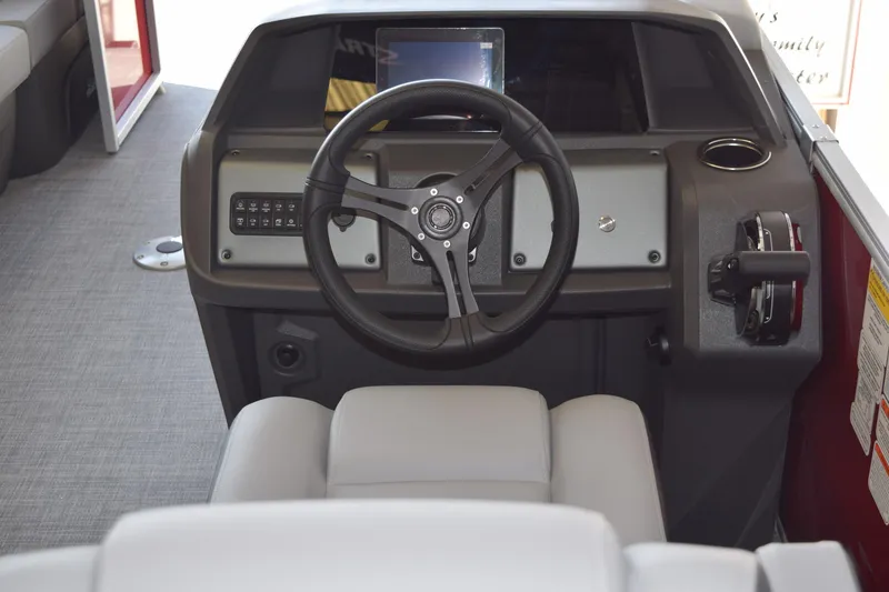 Slide: The Image of 2026 Sun Tracker Party Barge 22 RF DLX steering console with modern controls and seating. - 9