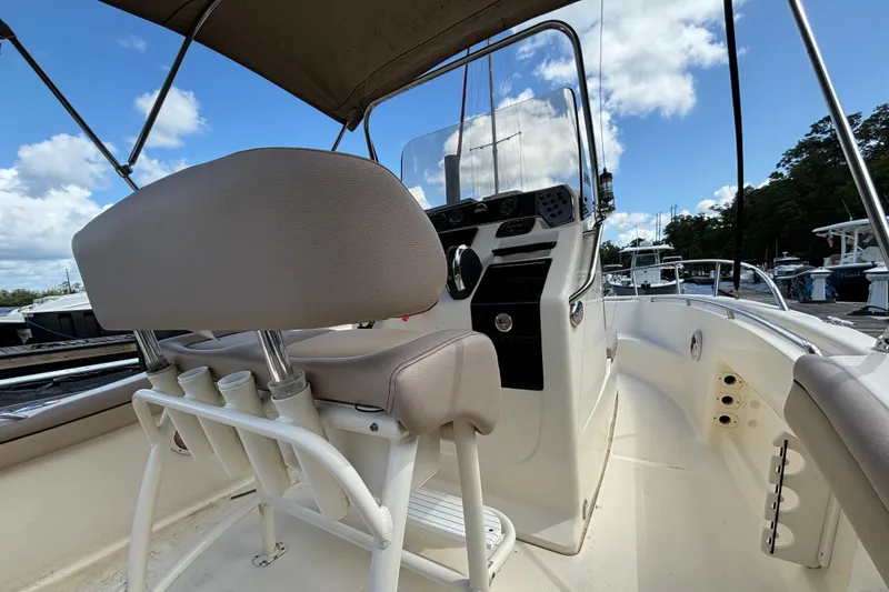 Slide: The Image of 2015 Scout 215 XSF boat interior with helm and seating under blue sky. - 7