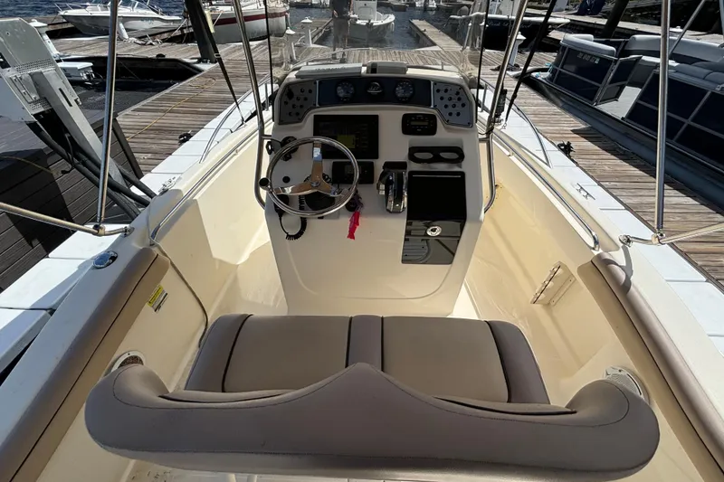 Slide: The Image of 2015 Scout 215 XSF boat interior with steering wheel and control panel at dock. - 9