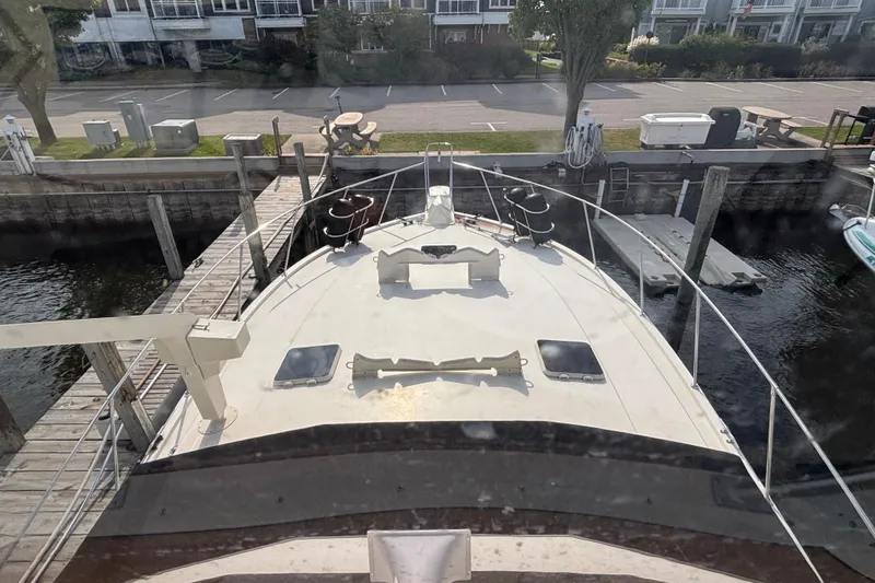 Slide: The Image of 1986 Viking 48 Convertible yacht docked at a marina, view from the deck. - 10