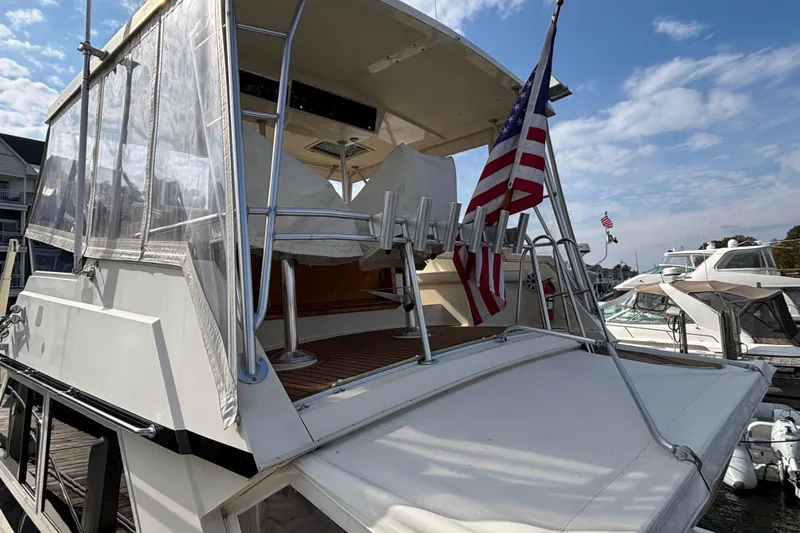 Slide: The Image of 1986 Viking 48 Convertible yacht with American flag at marina. - 12