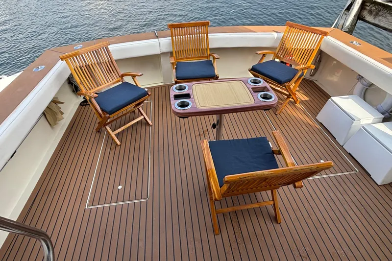 Slide: The Image of Deck of 1986 Viking 48 Convertible yacht with wooden chairs and table. - 15