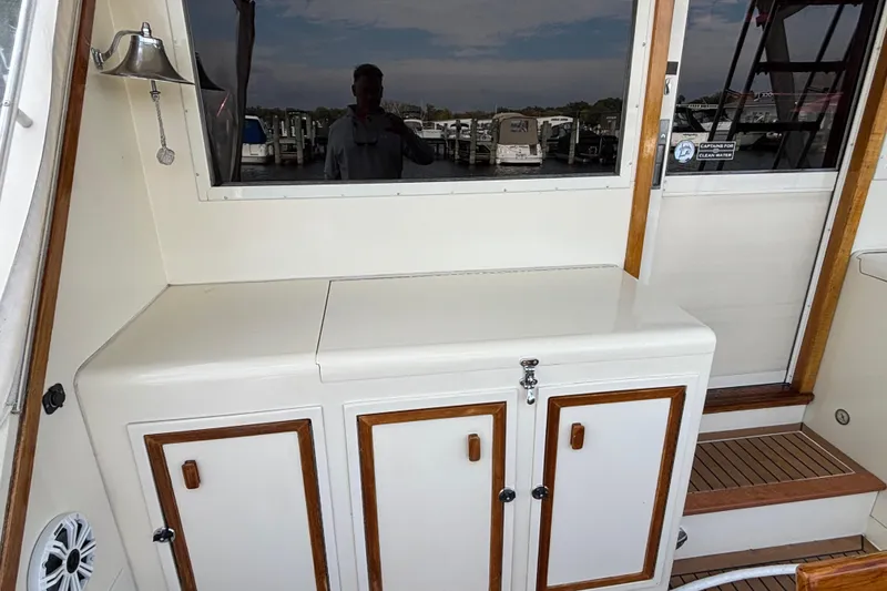Slide: The Image of 1986 Viking 48 Convertible yacht interior with storage cabinets and wooden accents. - 16
