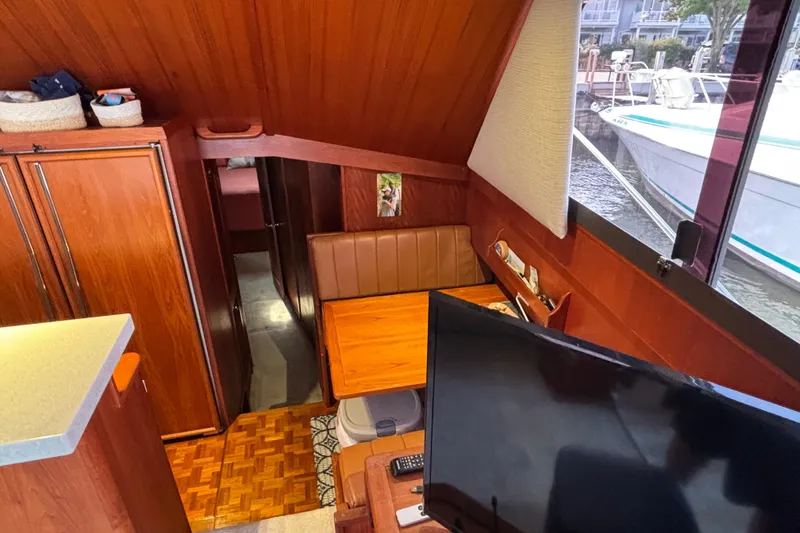 Slide: The Image of Interior of 1986 Viking 48 Convertible yacht with wood paneling and dining area. - 24