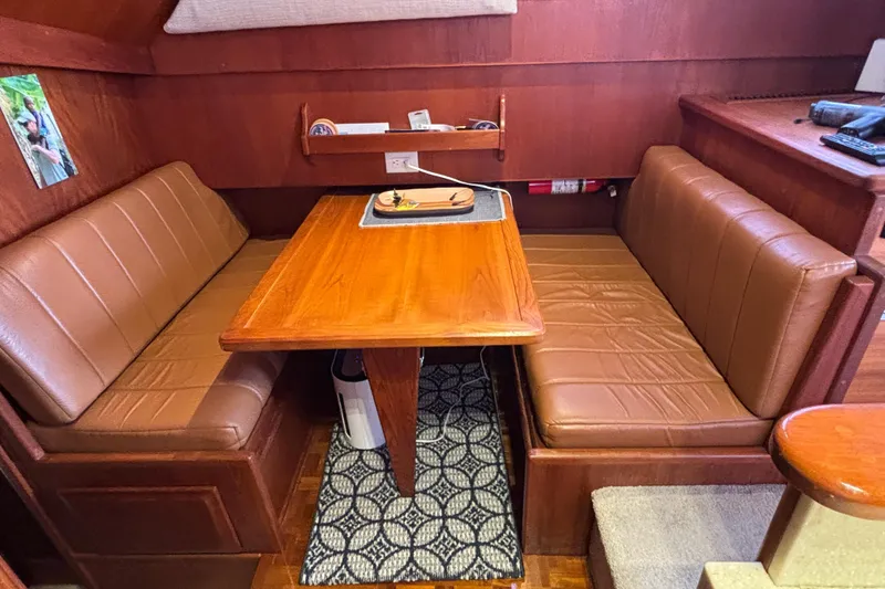 Slide: The Image of Interior of 1986 Viking 48 Convertible yacht with brown leather seating and wooden table. - 29