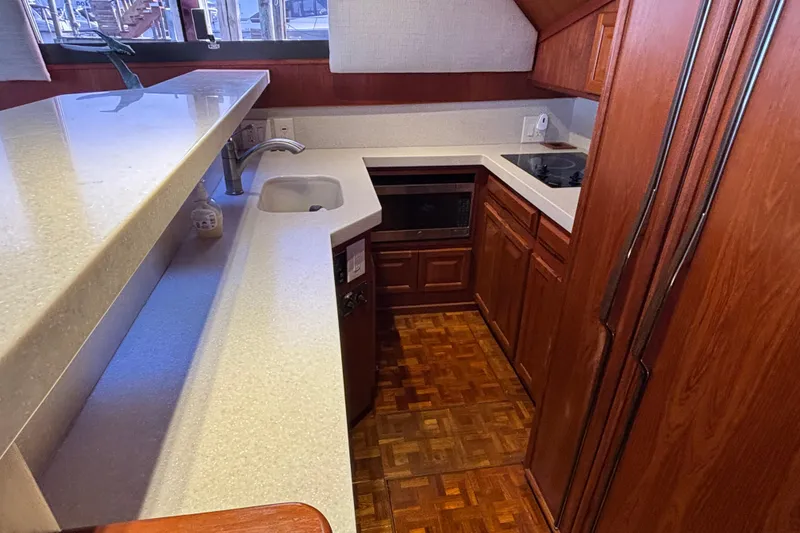 Slide: The Image of 1986 Viking 48 Convertible yacht kitchen with wood cabinetry and modern appliances. - 31
