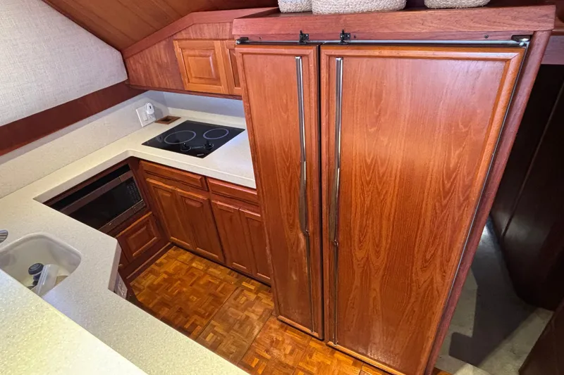Slide: The Image of 1986 Viking 48 Convertible yacht kitchen with wood cabinetry and modern appliances. - 32