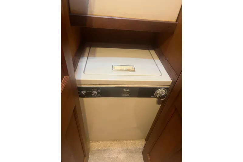 Slide: The Image of Washer unit inside a 1986 Viking 48 Convertible yacht, compactly fitted in a wooden cabinet. - 37