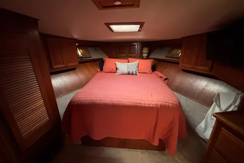Slide: The Image of Cozy bedroom in 1986 Viking 48 Convertible yacht with red bedding and wooden cabinetry. - 45