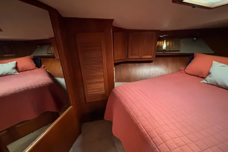 Slide: The Image of Cozy bedroom interior of 1986 Viking 48 Convertible yacht with red bedding and wooden cabinetry. - 46