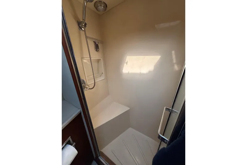 Slide: The Image of Shower area in 1986 Viking 48 Convertible yacht, featuring a handheld showerhead and built-in seat. - 50