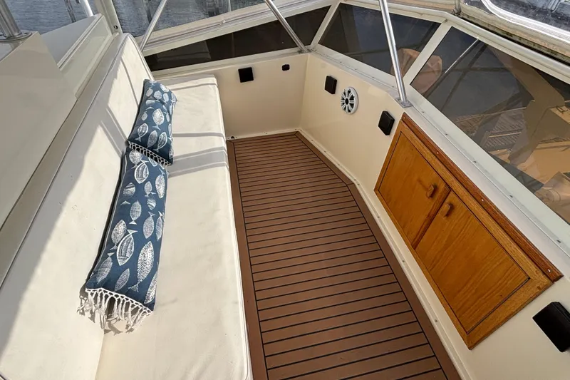 Slide: The Image of Interior of 1986 Viking 48 Convertible yacht with cushioned seating and wooden cabinetry. - 56