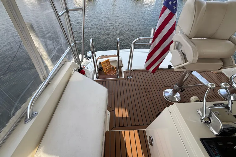 Slide: The Image of 1986 Viking 48 Convertible yacht deck with seating, controls, and American flag. - 59