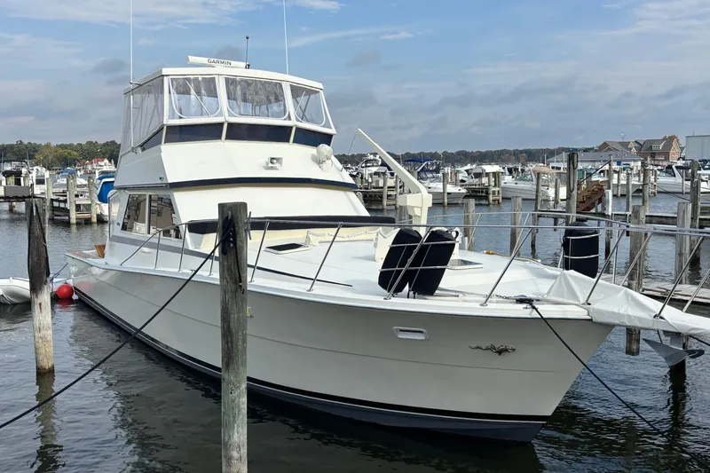Slide: The Image of 1986 Viking 48 Convertible yacht docked at a marina, featuring a spacious deck and flybridge. - 6