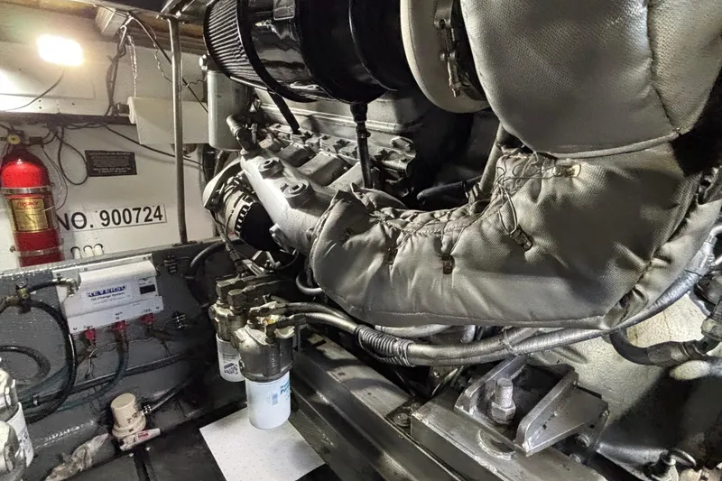 Slide: The Image of Engine room of a 1986 Viking 48 Convertible boat, featuring mechanical components and fire extinguisher. - 64