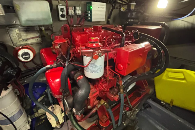 Slide: The Image of Engine room of 1986 Viking 48 Convertible boat with red machinery and components. - 68