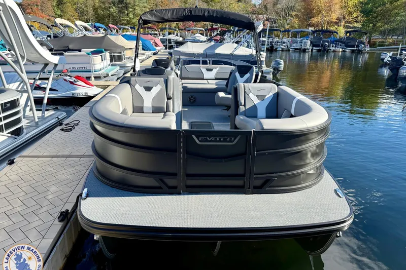 Slide: The Image of Luxury 2026 Evotti 523CS pontoon boat docked at marina, featuring sleek design and spacious seating. - 1