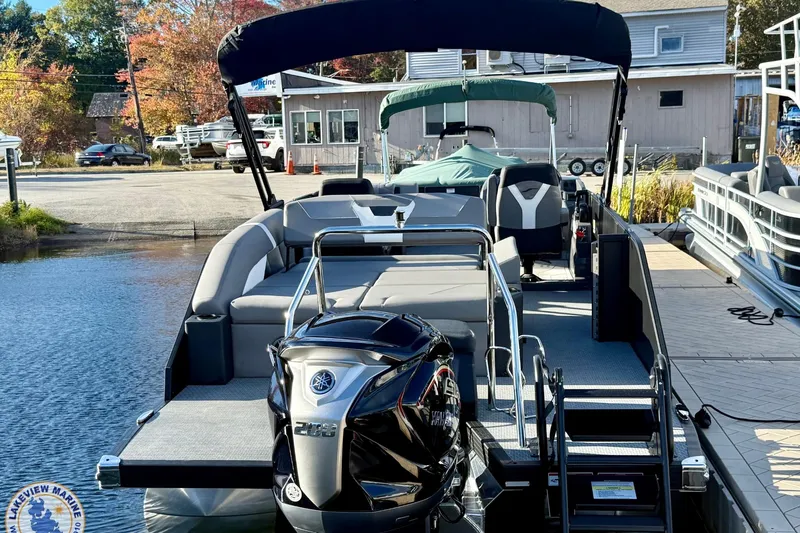 Slide: The Image of 2026 Evotti 523CS pontoon boat docked, featuring a sleek design and powerful outboard motor. - 2