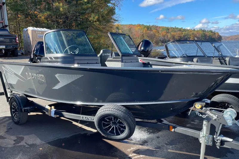The Image of 2026 Lund 1775 Adventure Sport boat on trailer by a lake in autumn. - 1