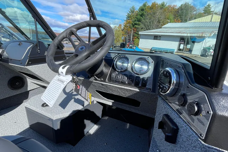 Slide: The Image of 2026 Lund 1775 Adventure Sport boat dashboard with steering wheel and gauges. - 3