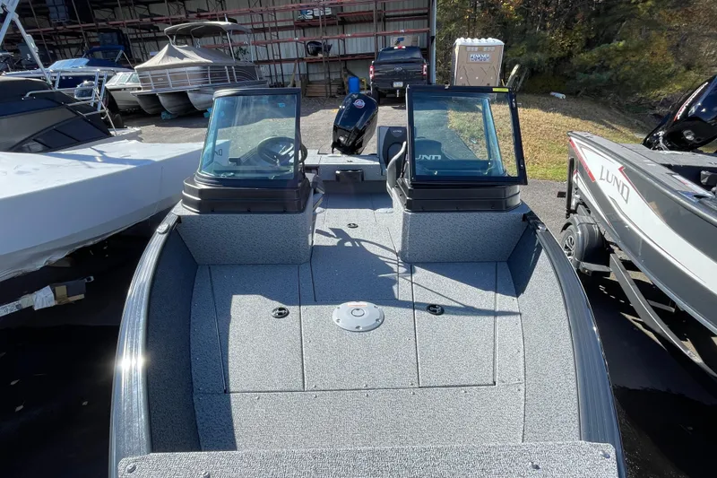 Slide: The Image of 2026 Lund 1775 Adventure Sport boat, dual windshields, parked outdoors among other boats. - 6