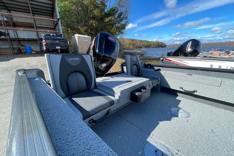 Slide: The Image of 2026 Lund 1775 Adventure Sport boat interior with seating, docked by a scenic lake. - 7