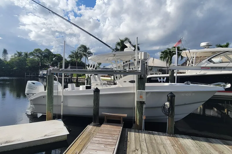 Slide: The Image of 2022 Twin Vee 260 CC SE Classic boat docked by a scenic waterfront. - 13