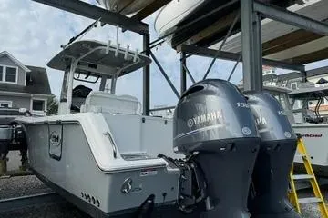 Slide: The Image of 2018 Sea Hunt Gamefish 27 boat with dual Yamaha engines in a marina. - 10