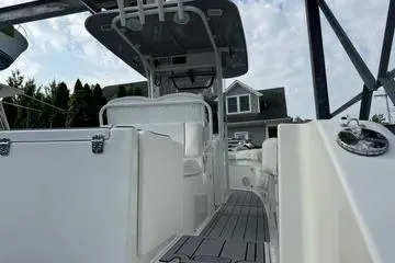 Slide: The Image of 2018 Sea Hunt Gamefish 27 boat, interior view with seating and console, under cloudy sky. - 12