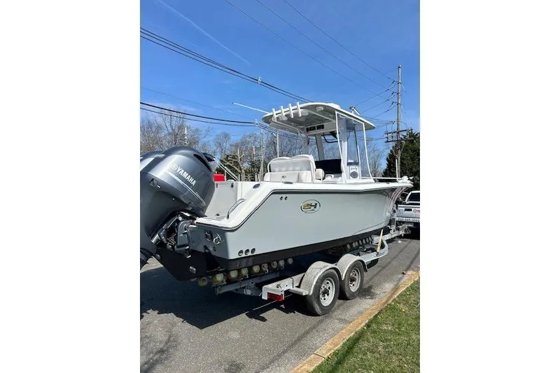 Slide: The Image of 2018 Sea Hunt Gamefish 27 boat on trailer with Yamaha engine, parked outdoors. - 15