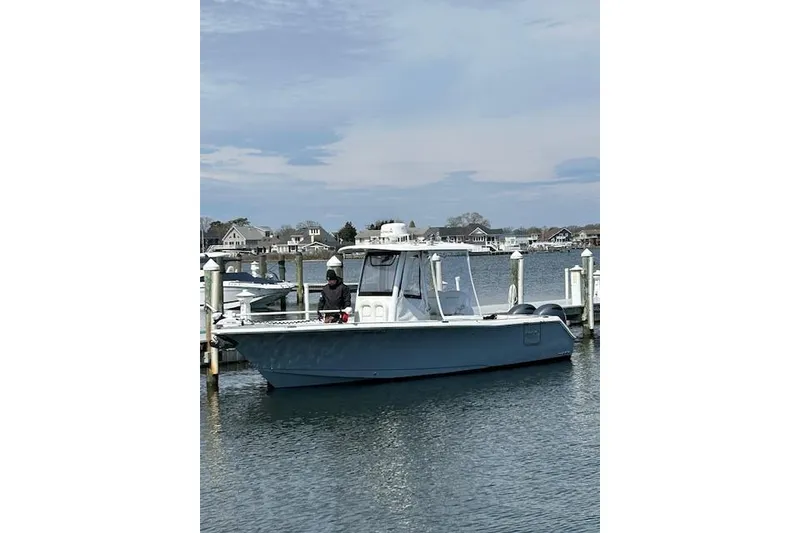 Slide: The Image of 2018 Sea Hunt Gamefish 27 boat docked in a marina, calm water, overcast sky. - 16