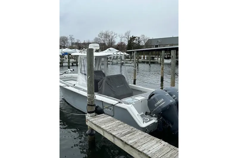 Slide: The Image of 2018 Sea Hunt Gamefish 27 boat docked with Yamaha engines, overcast day. - 17