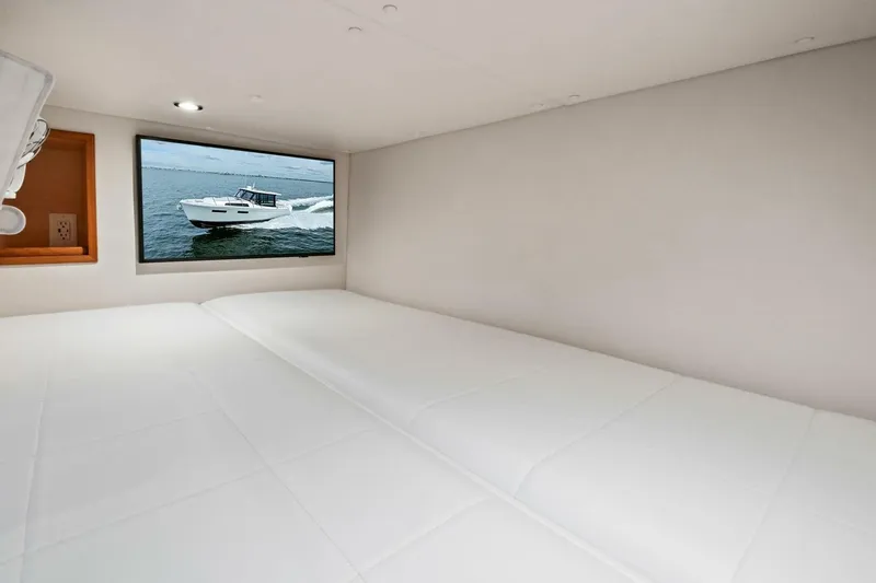 Slide: The Image of 2025 MJM 42 yacht cruising on open water under a cloudy sky. - 23