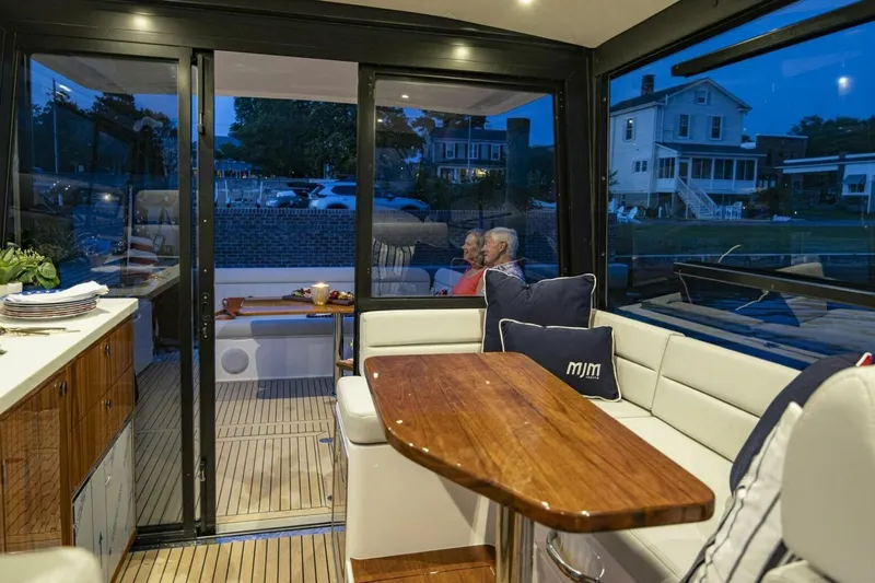 Slide: The Image of Luxurious interior of 2025 MJM 42 yacht with ocean view, featuring elegant seating and kitchenette. - 5