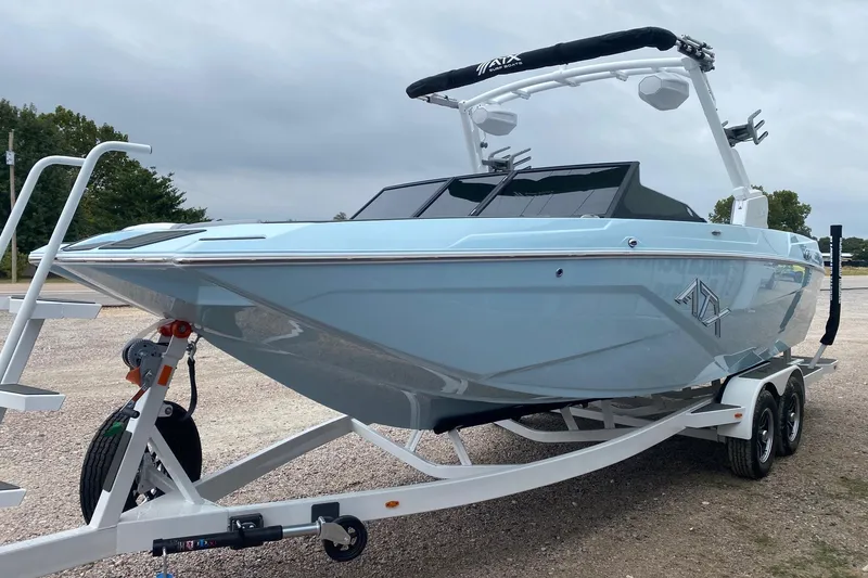 Slide: The Image of 2026 ATX Surf Boats 24 Type-S on trailer, light blue exterior, parked outdoors. - 2