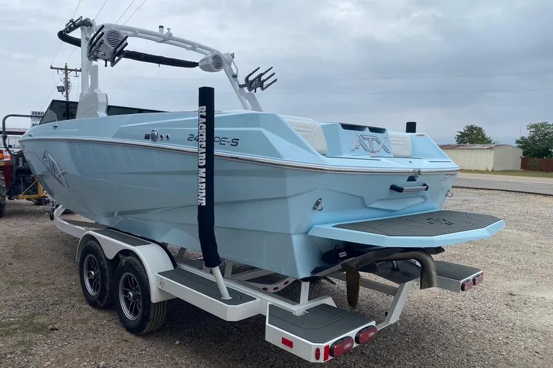 Slide: The Image of 2026 ATX Surf Boats 24 Type-S in light blue on a trailer, rear view. - 3