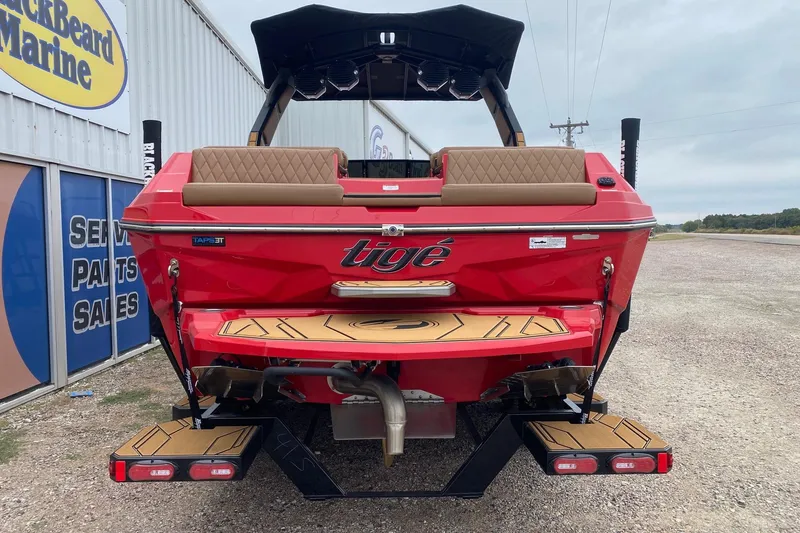 Slide: The Image of 2026 Tigé Z3 boat in red, rear view at a marine dealership. - 4
