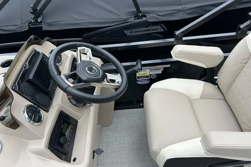 Slide: The Image of 2026 Avalon Venture Rear Bench boat interior with steering wheel and beige captain's chair. - 4
